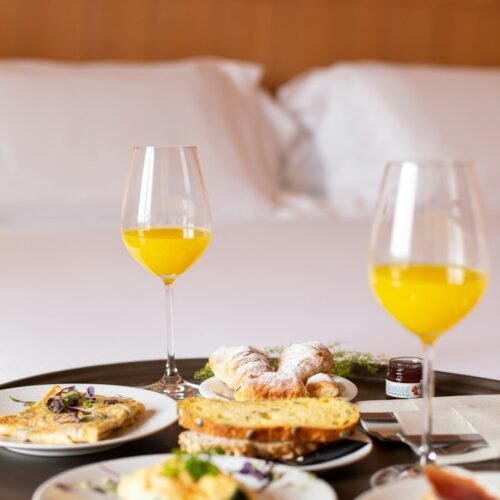 Breakfast in bed with orange juice and pastries.